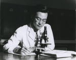 Jin Kinoshita ’44 takes notes beside a microscope, 1944.